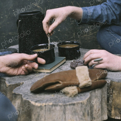Couple having coffee in a forest, two mugs of coffee, a coffee pot and a pair of… Couple having coffee in a forest, two mugs of coffee, a coffee pot and a pair of…