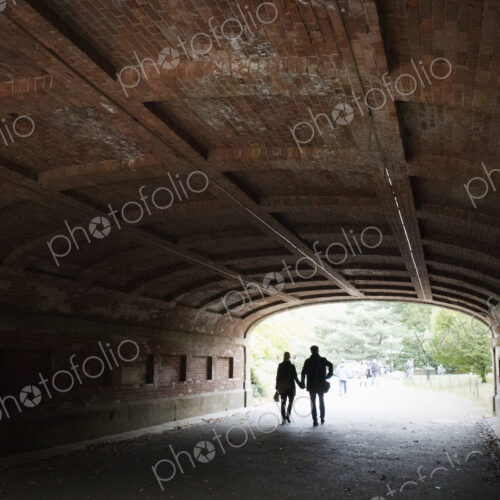 Couple holding hands walking through a tunnel in Central park, Manhattan. Couple holding hands walking through a tunnel in Central park, Manhattan.