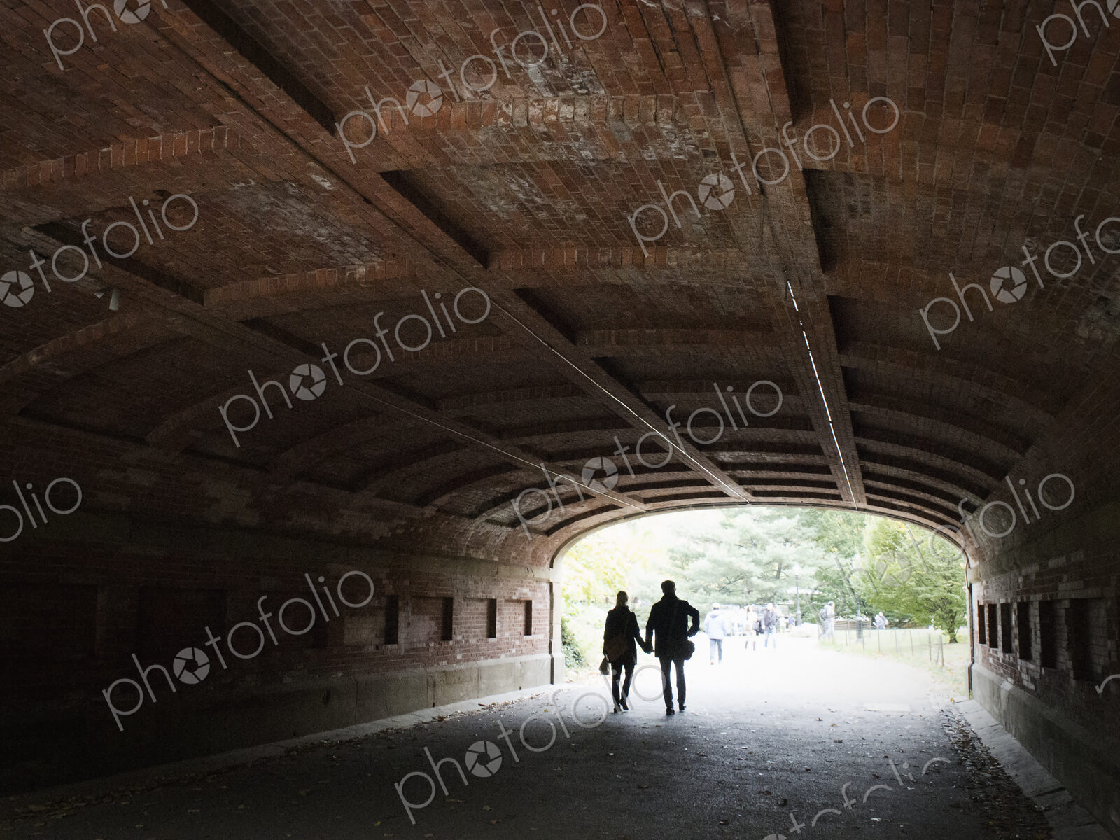 Couple holding hands walking through a tunnel in Central park, Manhattan.