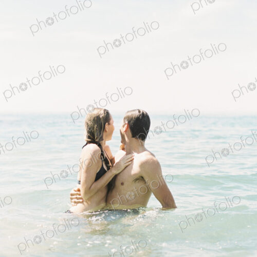 Couple hugging each other, in waist deep water.