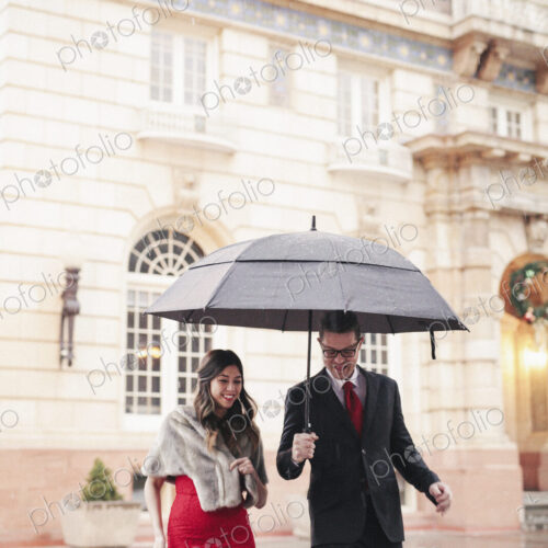 Couple in evening dress outside in wet weather in city Couple in evening dress outside in wet weather in city