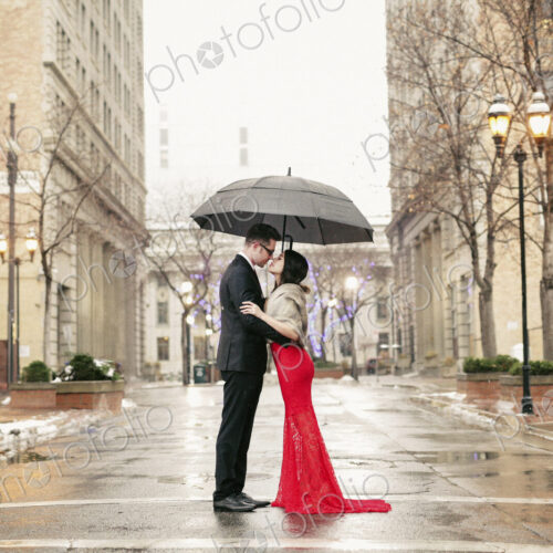 Couple in evening dress outside in wet weather in city Couple in evening dress outside in wet weather in city