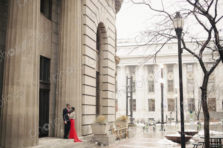 Couple in evening dress outside in wet weather in city