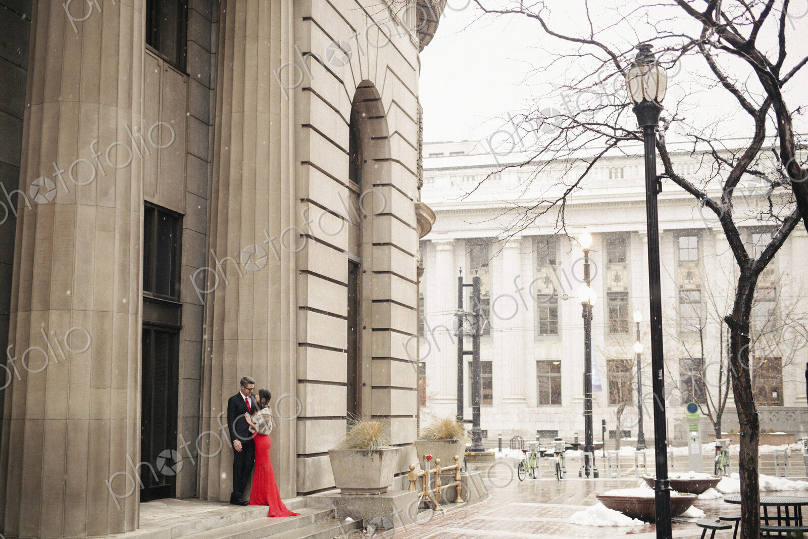 Couple in evening dress outside in wet weather in city