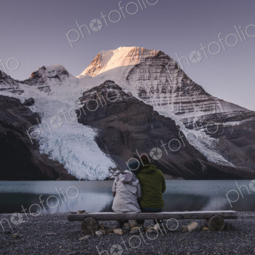 Couple in front of Mount Robson above Berg lake at dawn.