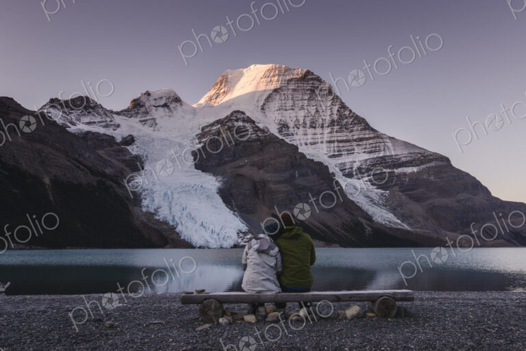 Couple in front of Mount Robson above Berg lake at dawn.