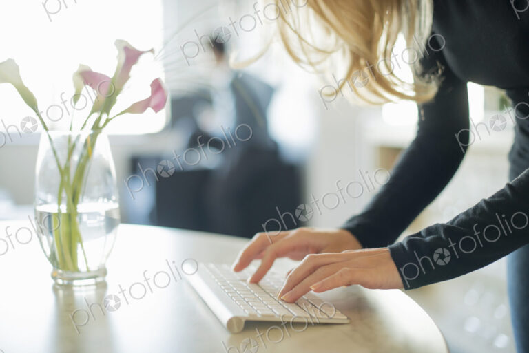 Couple relaxing at home, woman using keyboard