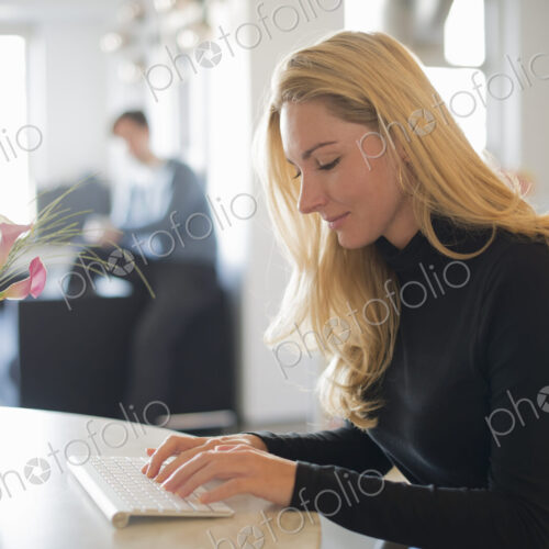 Couple relaxing at home, woman using keyboard Couple relaxing at home, woman using keyboard