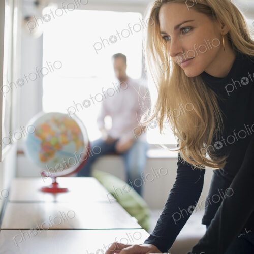 Couple relaxing at home, woman using keyboard, man using smartphone Couple relaxing at home, woman using keyboard, man using smartphone