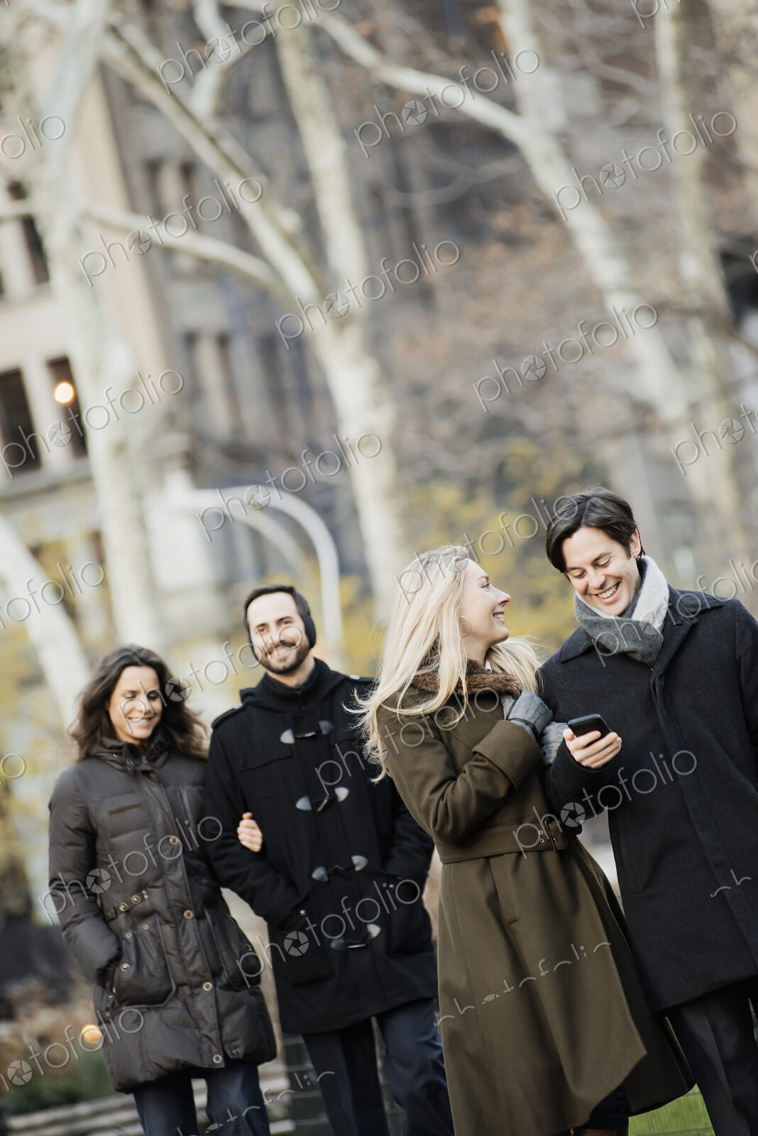 Couple walking in urban park with smartphone