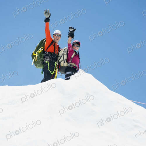 Couple waving on snowy mountain, Everest, Khumbu region, Nepal Couple waving on snowy mountain, Everest, Khumbu region, Nepal