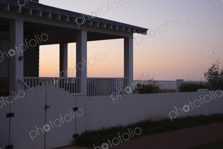 Covered Porch And Fence At Sunset
