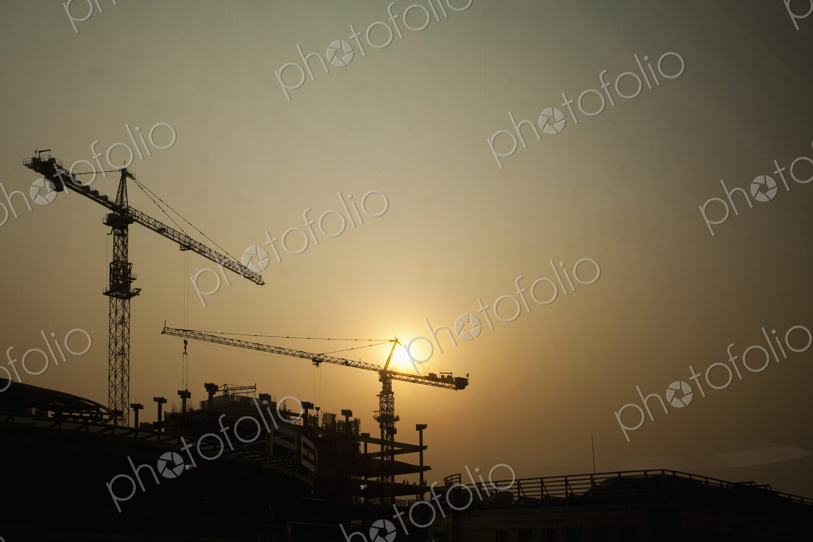 Crane on construction site at sunset.