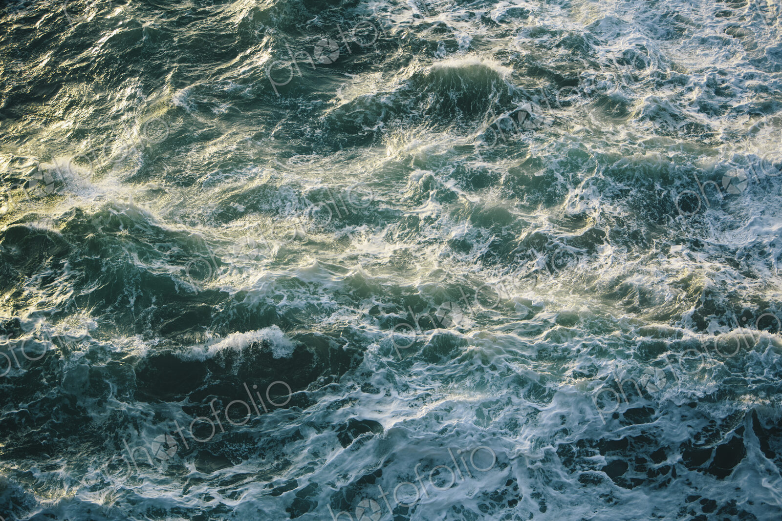Crashing waves and surf, green and turquoise colours in the ocean, view from above.
