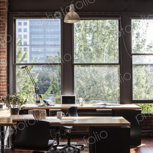 Creative office interior. View through a window to trees and city buildings. Creative office interior. View through a window to trees and city buildings.