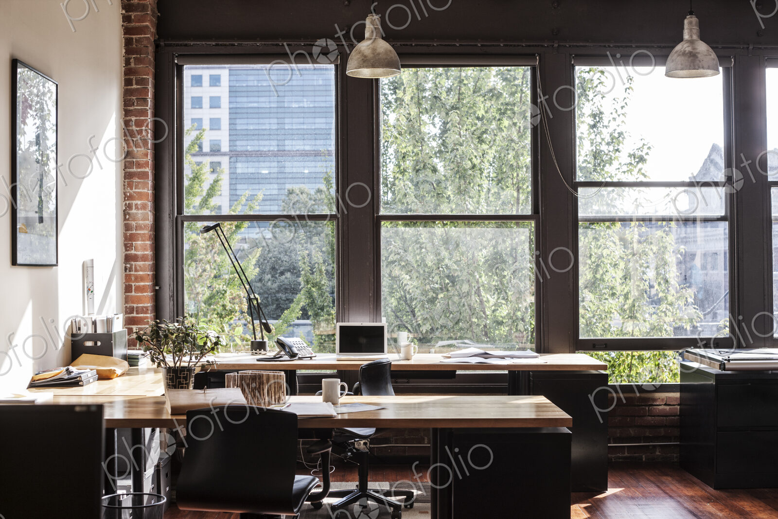 Creative office interior. View through a window to trees and city buildings.
