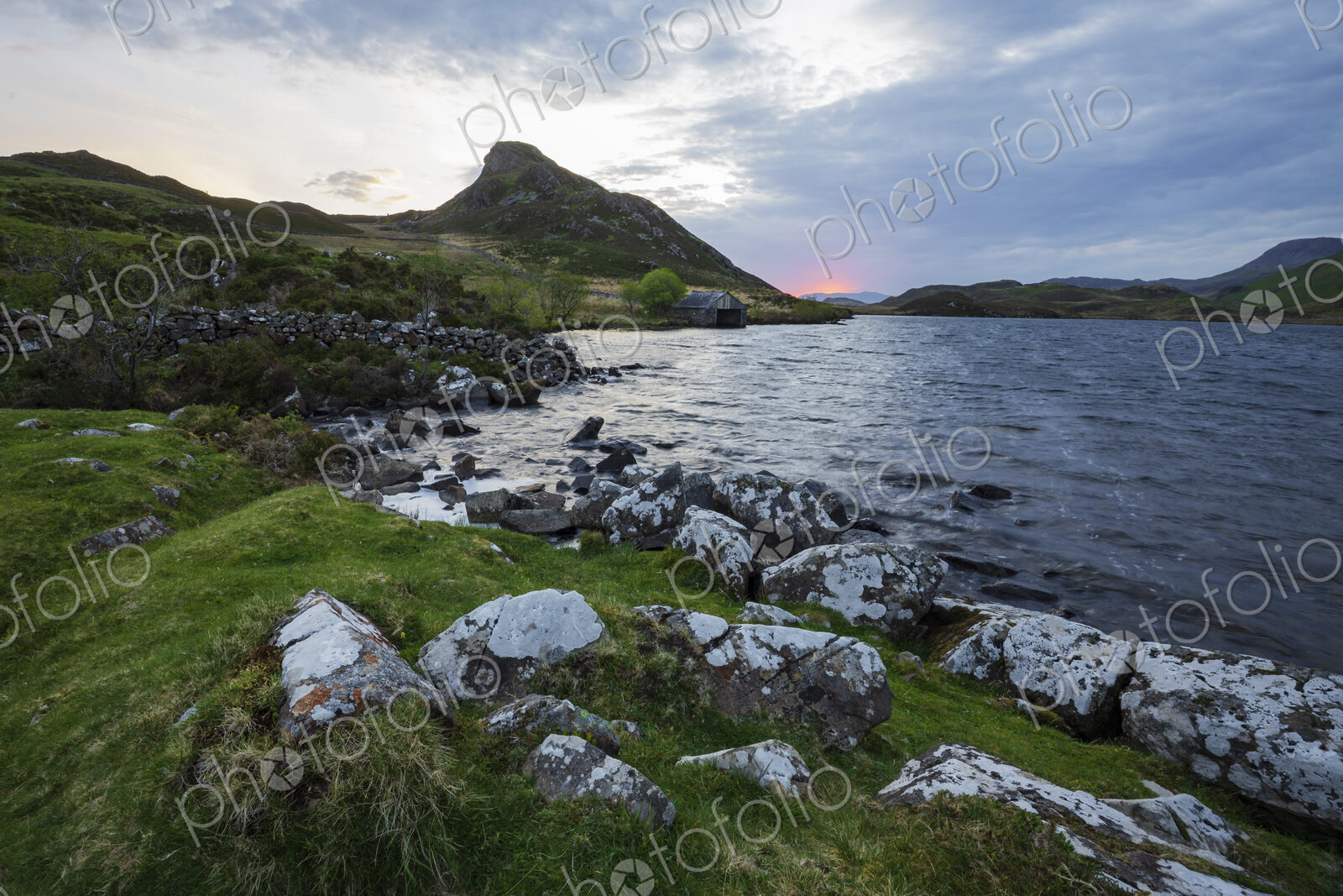 Cregennen Lakes at sunrise, a cloudy sky, the shoreline of the lake.