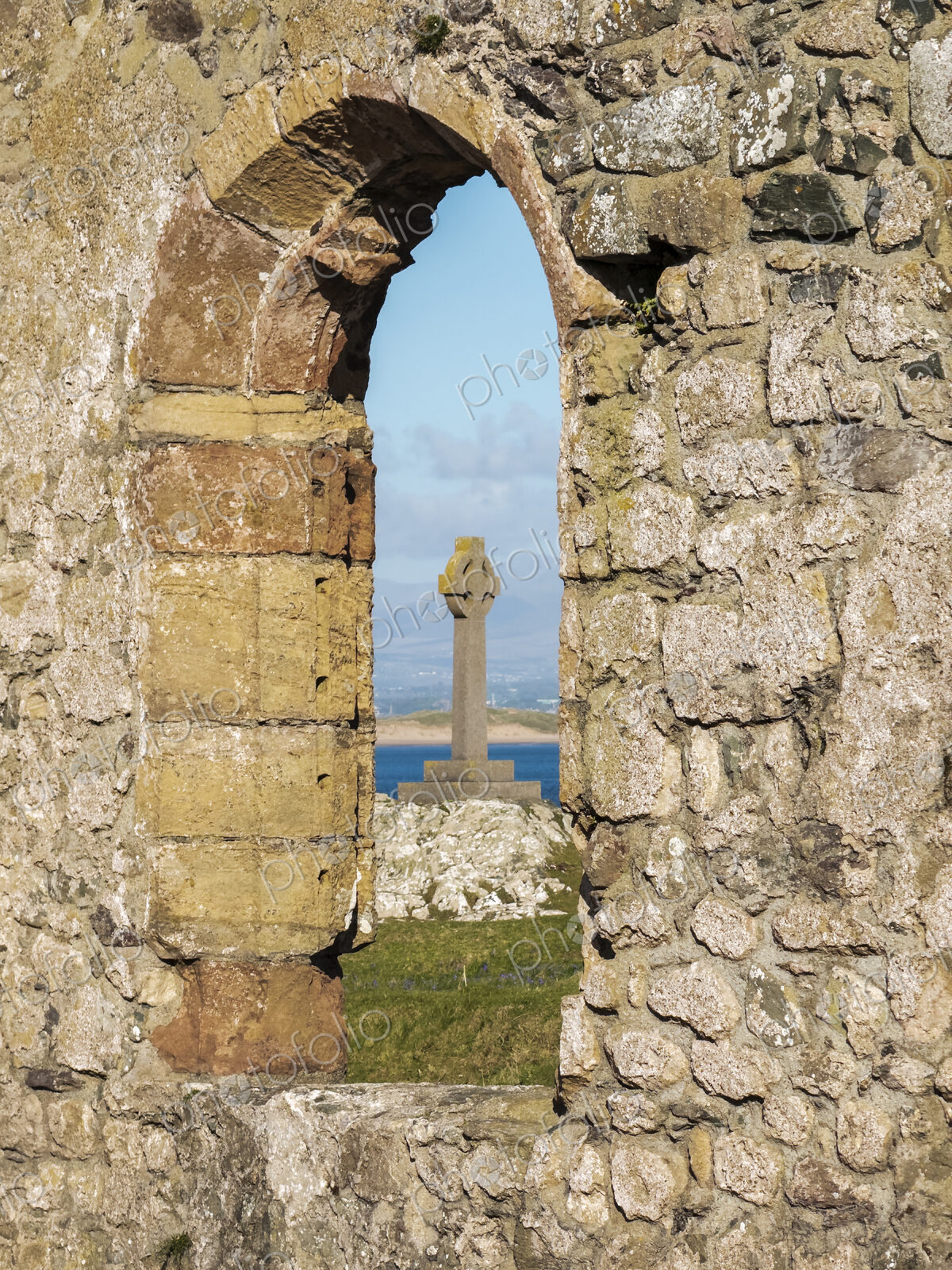 Cross of St David seen through the window arch of a ruined church, Eglwys Santes…