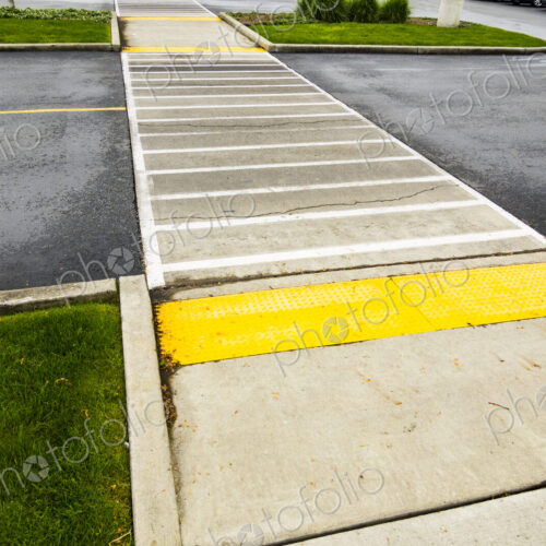 Crosswalk for pedestrians on a two lane road, coloured paving and white lines on the road. Crosswalk for pedestrians on a two lane road, coloured paving and white lines on the road.