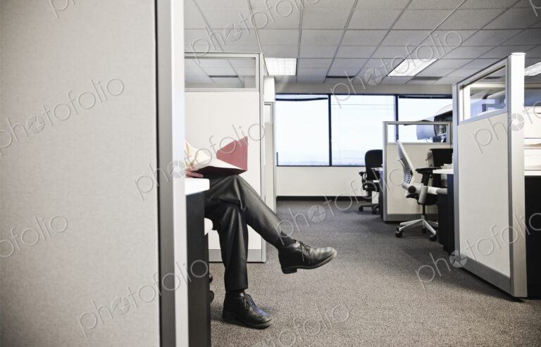 Cubicle office set up with business person going over paperwork.