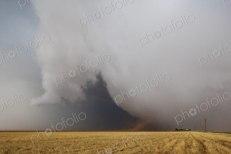 Cumulonimbus Clouds meeting the ground on the horizon, a dark shape and lighter clouds…