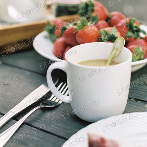 Cup of tea and plate of fresh strawberries on a table. Cup of tea and plate of fresh strawberries on a table.
