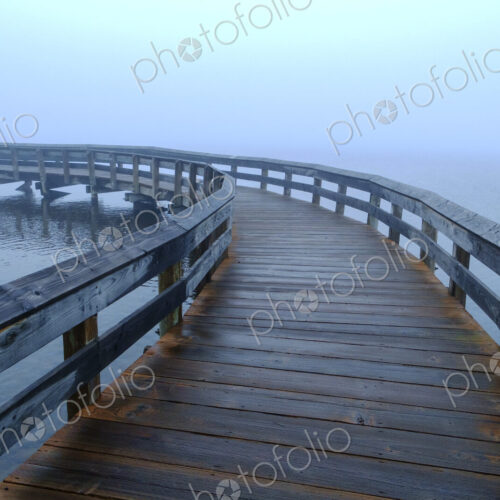 Curving boardwalk in fog Curving boardwalk in fog