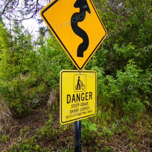 Curvy arrow road sign and warning of steep grade, Spokane, WA USA