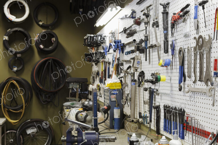 Cycle repair shop interior, tool boards and tools at a service counter.