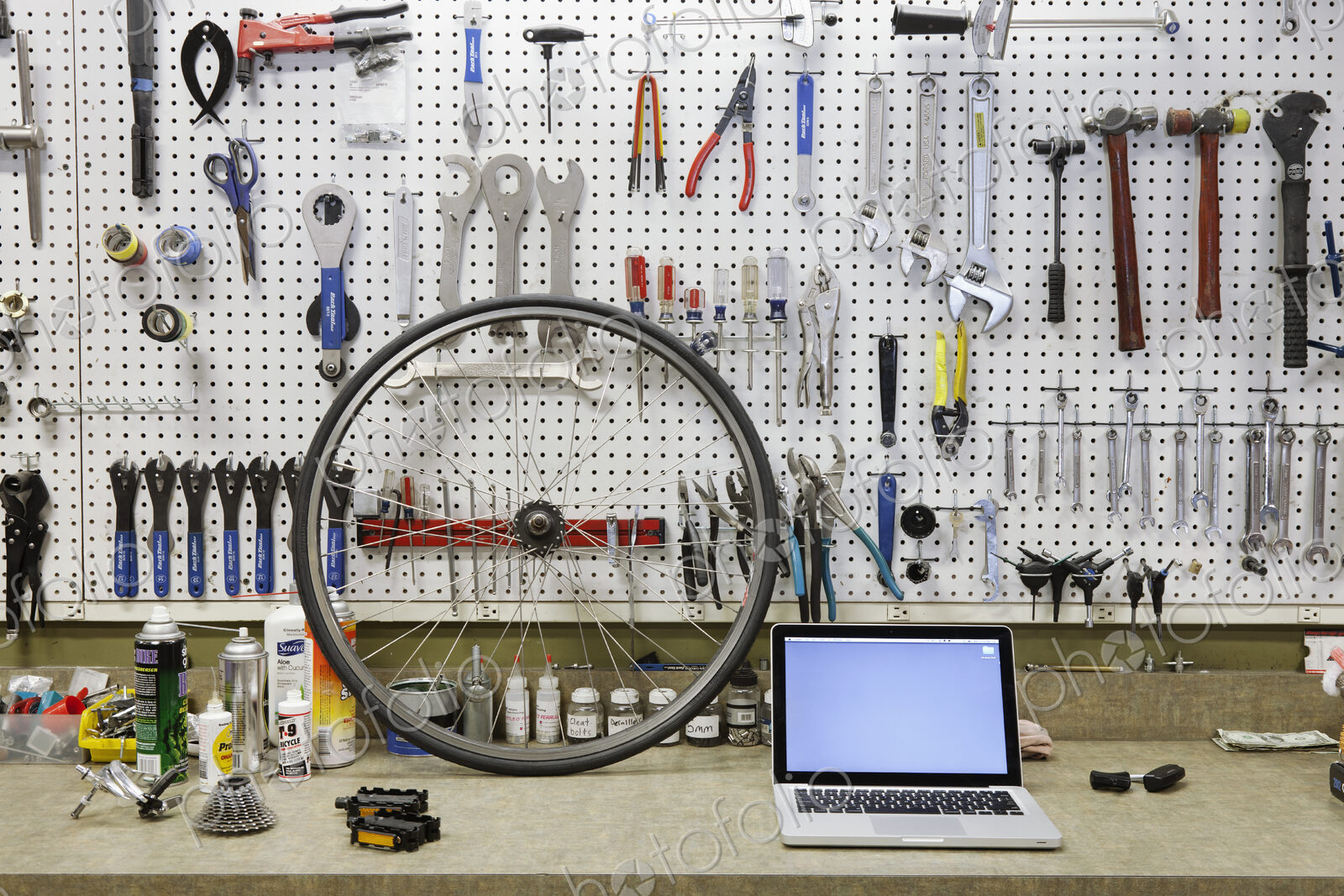 Cycle repair shop interior, tool boards and tools at a service counter.