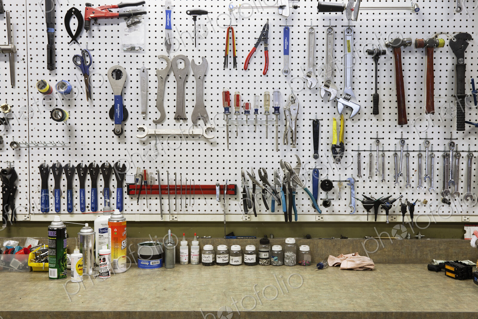Cycle repair shop interior, tool boards and tools at a service counter.