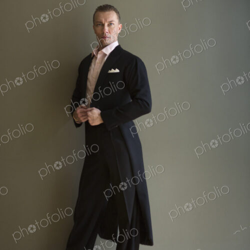 Dancer in dance studio. A man in a frock coat.