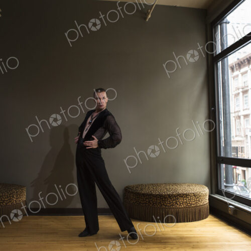 Dancer in dance studio. A man standing with his back arched.