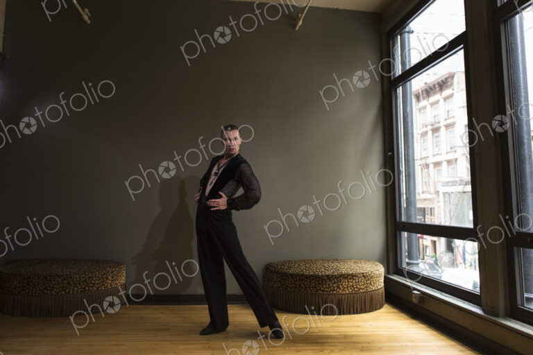 Dancer in dance studio. A man standing with his back arched.
