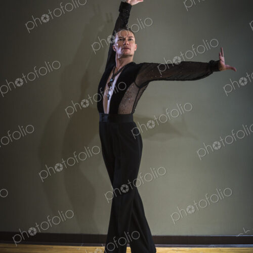 Dancer in dance studio. A man with one arm stretched out and one arm raised. Dancer in dance studio. A man with one arm stretched out and one arm raised.