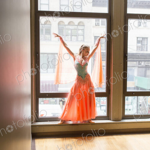 Dancer in dance studio. A woman posing at a window.