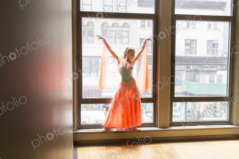 Dancer in dance studio. A woman posing at a window.