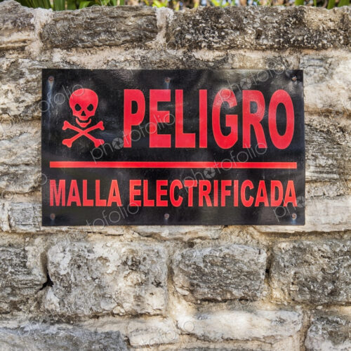 Danger sign in Spanish on a stone wall in Cancun, Electricity supply.