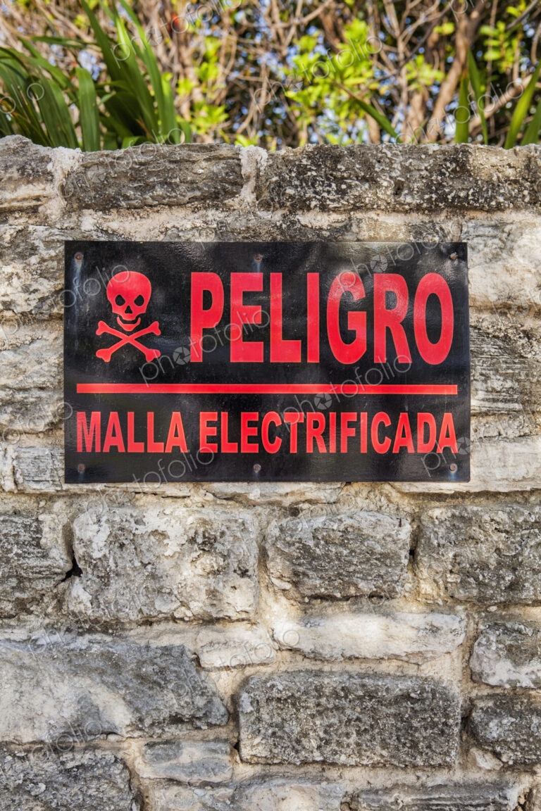 Danger sign in Spanish on a stone wall in Cancun, Electricity supply.