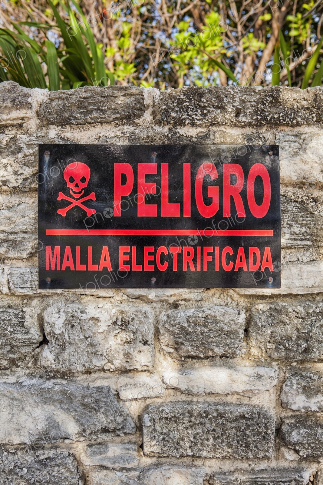 Danger sign in Spanish on a stone wall in Cancun, Electricity supply.