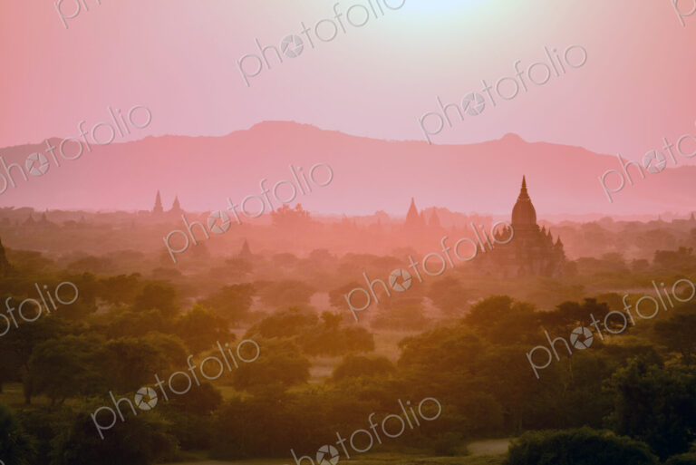 Dawn and mist in the air above temple on the plain in Mandalay.