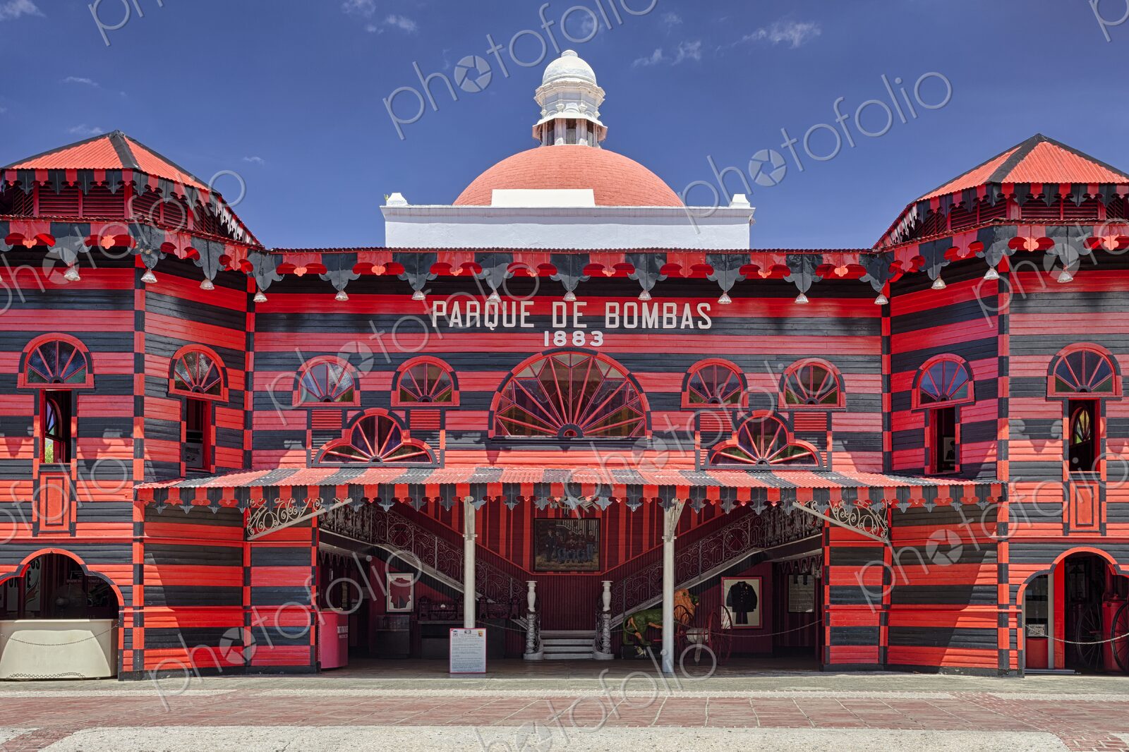 Daytime view of the iconic Parque de Bombas in Ponce, Puerto Rico. The vibrant red and…