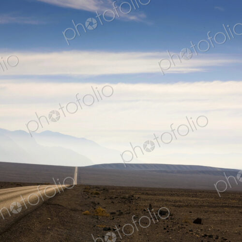 Death Valley, the highway through the arid rolling landscape reaching into the distance. Death Valley, the highway through the arid rolling landscape reaching into the distance.