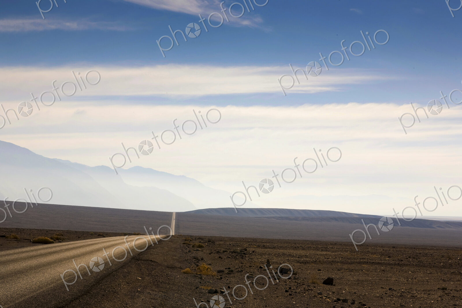 Death Valley, the highway through the arid rolling landscape reaching into the distance.