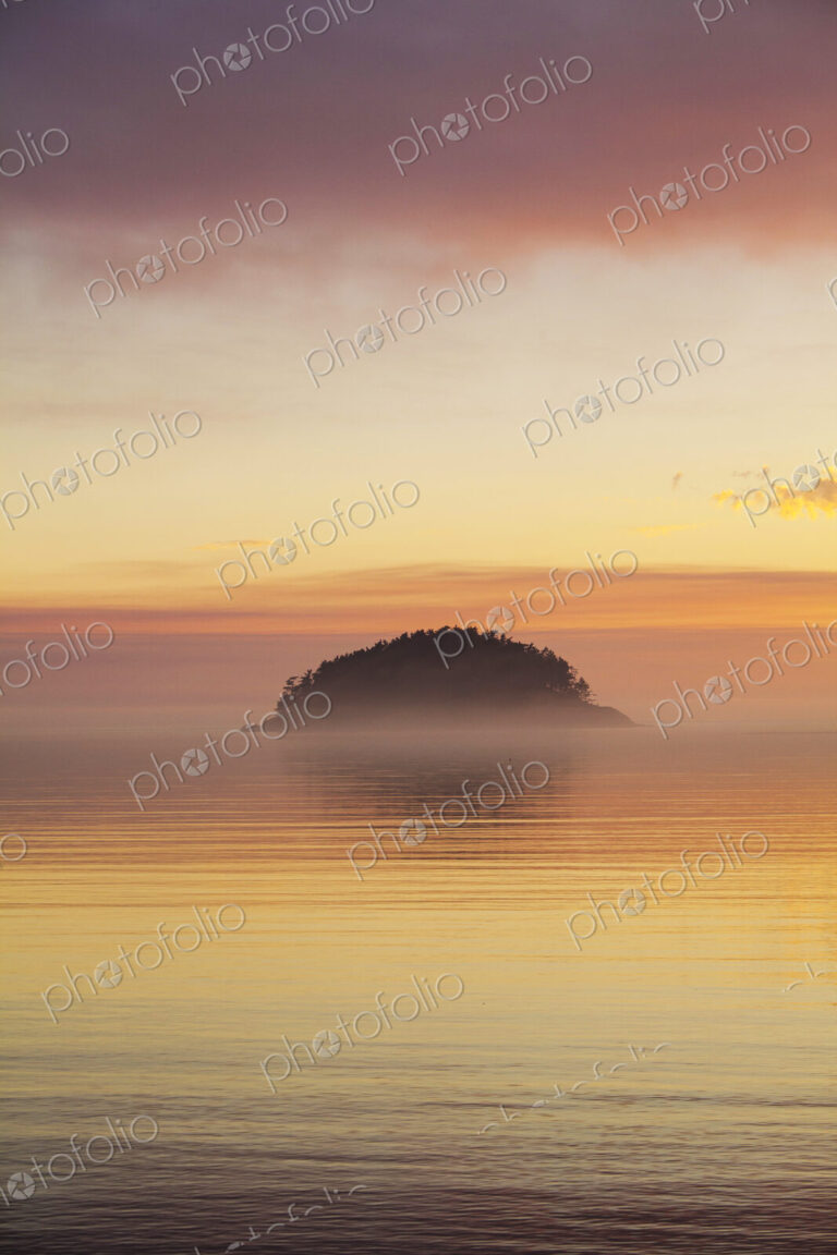 Deception Island, offshore on the coastline of Deception Pass State Park, a silhouette…