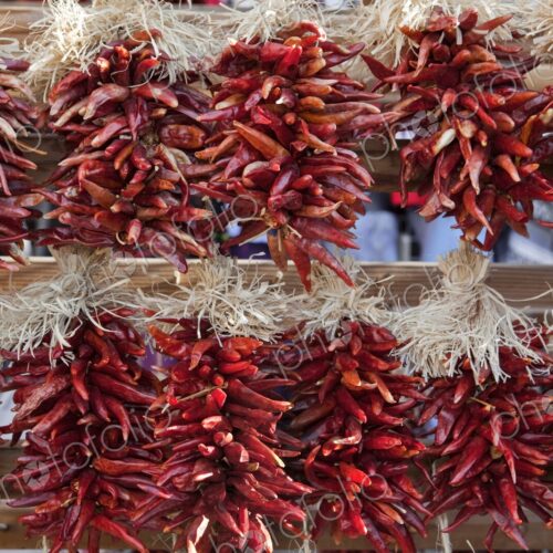 Decorative arrangements of dried chili peppers, called ristras, hanging for sale in… Decorative arrangements of dried chili peppers, called ristras, hanging for sale in…