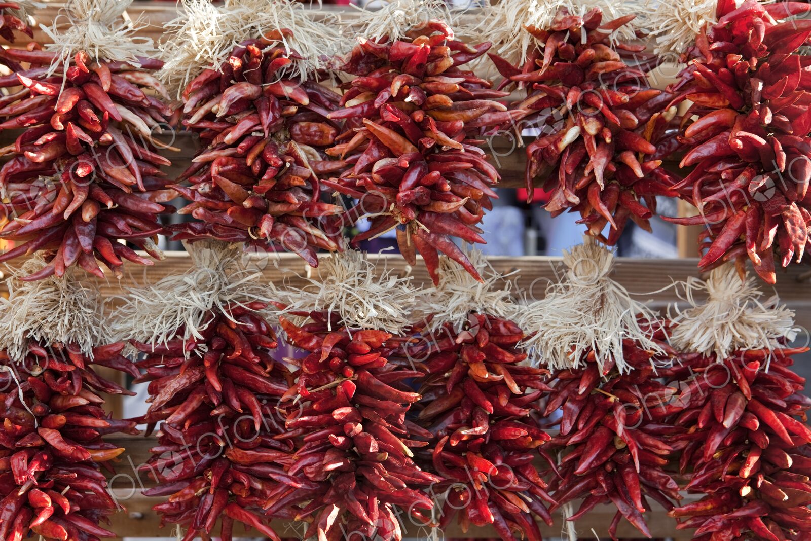 Decorative arrangements of dried chili peppers, called ristras, hanging for sale in…