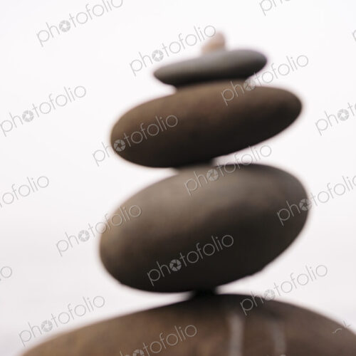 Defocussed stack of balancing stones in decreasing size on a white background. Defocussed stack of balancing stones in decreasing size on a white background.