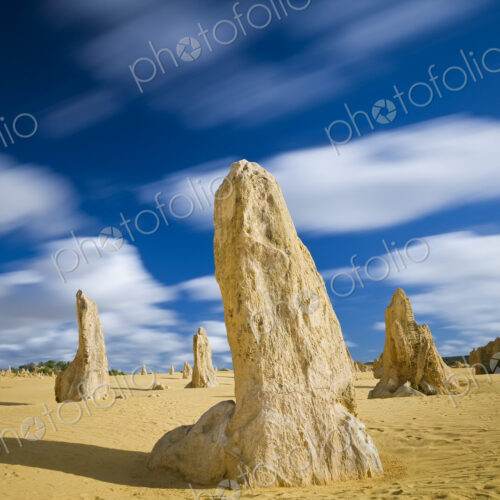 Desert landscape dotted with limestone pinnacles under a cloudy sky. Desert landscape dotted with limestone pinnacles under a cloudy sky.