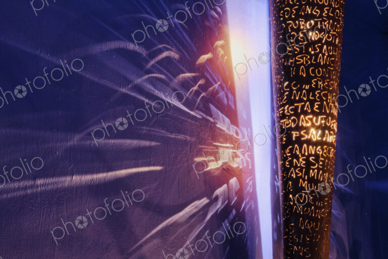 Designer Light Fixture, close up of a surface covered in letters, and light rays on a…